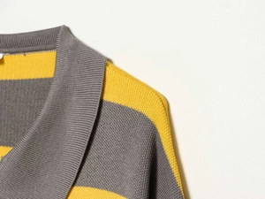 Detail of ribbed collar and grey-yellow striped knit texture of the sweater