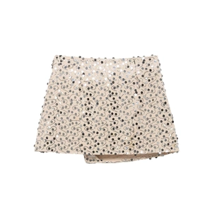 Close-up of sparkling silver and black sequins in a spiral pattern on a mini skirt