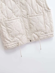 Detail der beige gesteppten Weste mit Wellenmuster, aufgesetzten Taschen und Tunnelzug