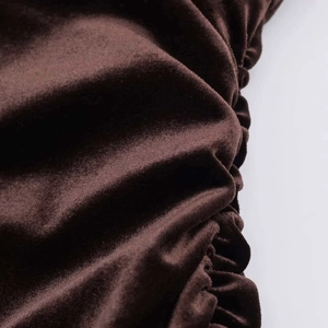 Détail du tissu en velours marron chocolat avec fronces élégantes et reflets doux