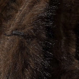 Detailed macro view of dark brown faux fur texture with a black elastic adjustment cord