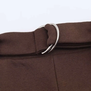 Detail of dark brown trousers waist featuring a classic silver double D-ring metal buckle