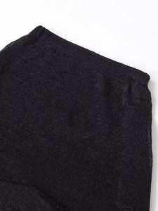 Dettaglio della gonna in maglia nera con vita elastica e trama a rete trasparente