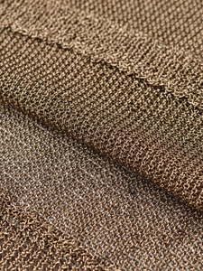 Macro detail of bronze metallic knit fabric showing the intricate hollow mesh texture