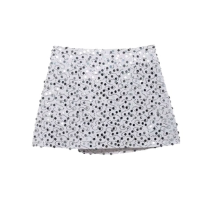 Detail of white mini skirt with intricate silver sequin wave patterns and metallic finish