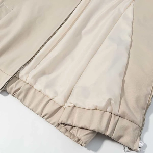 Detail of light beige jacket lining with metal zipper and elastic waistband hem