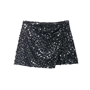 Detail showing shimmering silver sequins arranged in circular patterns on a black mini skirt