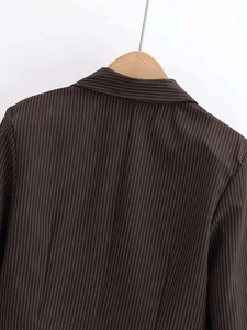 Close-up of a brown pinstripe V-neck cardigan with white stripes on a wooden hanger