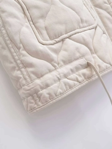 Detail der gesteppten Weste mit Wellenmuster, großer Tasche und verstellbarem Kordelzug