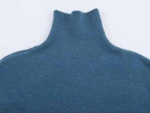Close-up of the ribbed turtleneck detail on a soft dark teal knitted sweater garment