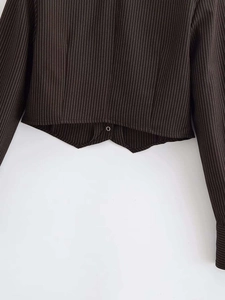 Detail of V-neck brown striped cardigan with unique pointed hem and metal button