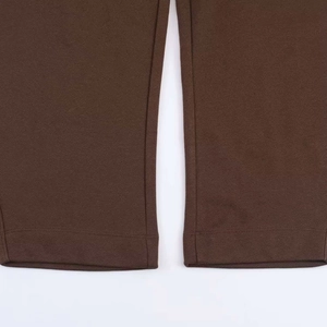 Detail of double-needle stitched hem on dark brown cropped trousers for women