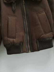 Detail of dark brown faux suede bomber jacket with soft faux fur collar and metal zipper