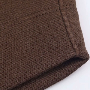 Close-up of dark brown knit fabric with fine texture and durable double-stitch seam detail