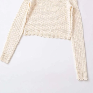 Cream knit long sleeve top with diamond eyelet patterns and scalloped wave hem edges