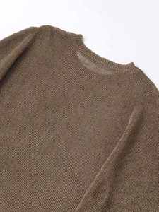 Detailed view of dark brown knitted texture on a loose batwing sleeve round neck sweater