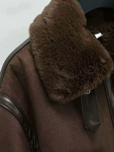 Detail of dark brown faux suede shearling jacket showing the plush collar and shoulder stitching
