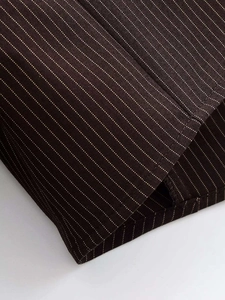 Macro view of dark brown fine pinstripe fabric with detailed stitching and texture