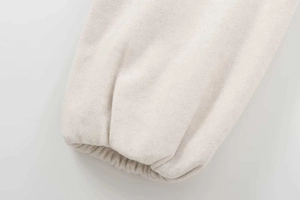 Detail view of soft fleece cuffs on a beige bomber jacket with elastic stitching