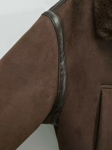 Detailed view of brown faux suede jacket with plush faux fur collar and leather piping