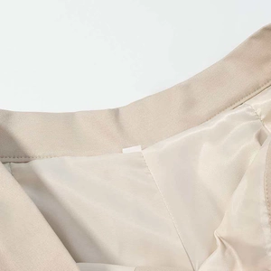 Detailed close-up of khaki twill fabric stitching and smooth satin lining on jacket