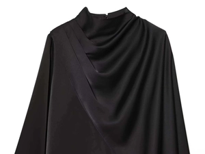 Detailed view of elegant draped neckline on smooth black satin long-sleeved shirt