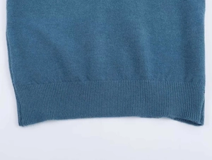 Close-up of blue knit sweater hem showing soft fabric texture and ribbed cuff detail