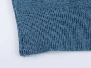 Close-up of blue knit sweater ribbed hem showing soft plush fabric texture and detail