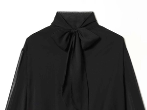 Close-up of black chiffon shirt featuring elegant pussy-bow tie and sheer puff sleeves
