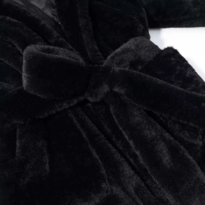 Détail du manteau noir en fausse fourrure avec texture douce et doublure matelassée