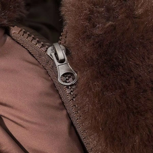 Close-up of fluffy faux fur collar and durable metal zipper on brown quilted jacket