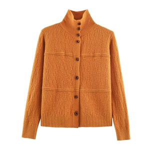 Detailed texture of mustard yellow knit cardigan featuring ribbed collar and brown buttons