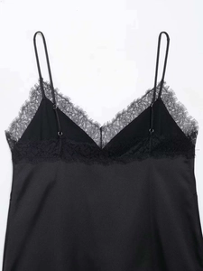 Detail of elegant black satin camisole featuring delicate eyelash lace trim and thin straps