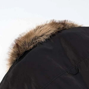 Close-up of winter jacket collar with premium brown faux fur trim and black outer shell