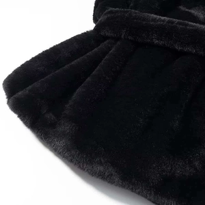 Détail de la texture de fourrure synthétique noire douce et fibres du manteau d'hiver