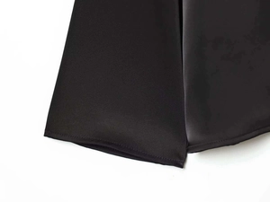 Detail of premium black satin fabric showing high-quality hem stitching and silk texture