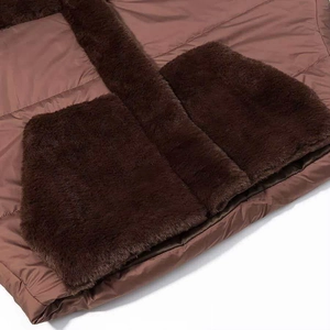 Detailed close-up of dark brown windproof fabric and thick faux fur textures on winter jacket