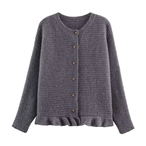 Detailed close-up of dark grey knit cardigan featuring ruffles and vintage buttons