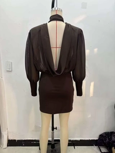 Detail of deep brown draped open back mini dress with sheer long sleeves on mannequin