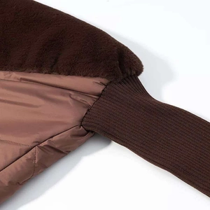 Detail of brown patchwork winter jacket with faux fur, quilted fabric and ribbed cuffs
