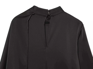 Detail view of black satin blouse featuring a high neck with buttons and teardrop cutout back