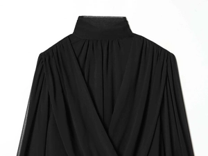 Detail of elegant black sheer pleated blouse featuring crossover high-neck design