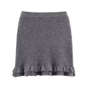 Detailed view of grey knitted mini skirt with elastic waist and ruffled fishtail hemline