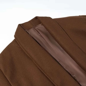 Détail du col d'un manteau en laine marron foncé avec doublure satinée et coutures fines