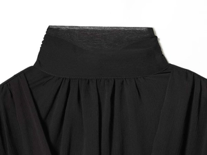 Close-up of black pleated stand collar on a sheer textured chiffon blouse for women