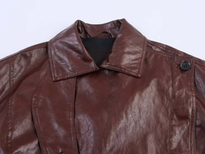 Detailed macro view of dark brown faux leather jacket collar and button texture