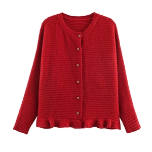 Close-up of red knit cardigan with wood-style buttons and ruffle hem detail