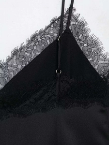 Detailed close-up of delicate eyelash lace trim and adjustable straps on black satin camisole