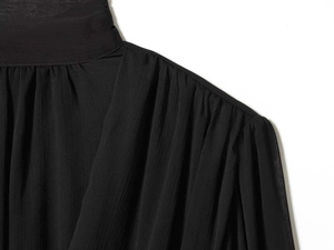 Detail of black pleated chiffon shirt featuring high stand-up collar and ruffled shoulders