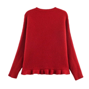 Detail view of red ribbed knit sweater featuring a stylish ruffled hem and long sleeves